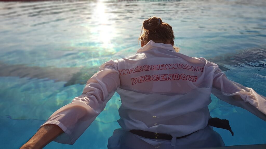 Schwimmer in Kleidung beim Sprung ins Wasser